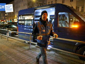 Ein Mitarbeiter der Berliner Stadtmission verteilt heiße Getränke.
