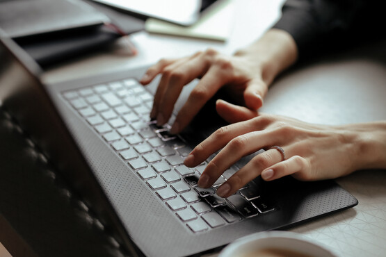 Frau tippt auf einer Laptop Tastatur